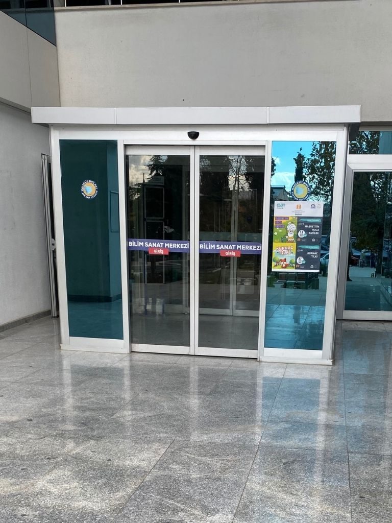 Geniş iç girişte alüminyum çerçeveli fotoselli cam kapı